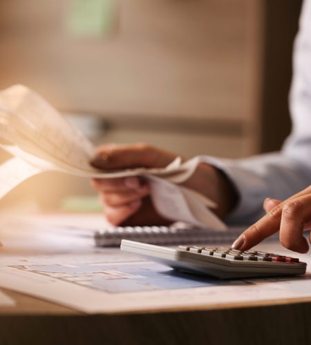 Close-up of business accountant using calculator while working i